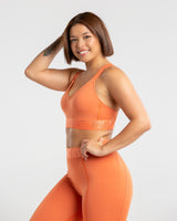 Woman in black sports bra and black shorts holding orange bottle photo –  Free Fitness Image on Unsplash